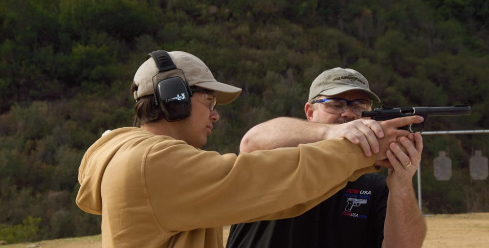 A CCW USA instructor guiding a student's grip during one-on-one range training